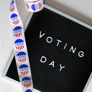 Picture of Voting Day sign with a roll of I Voted stickers. Photo by Element5 Digital, pexels.com
