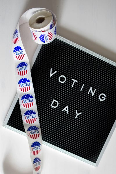 Picture of Voting Day sign with a roll of I Voted stickers. Photo by Element5 Digital, pexels.com